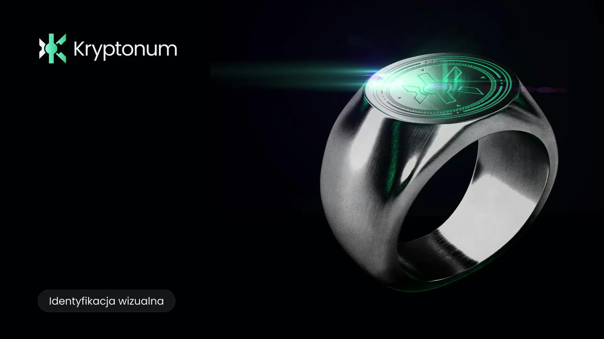 Pierścień z grawerem logo Kryptonum, czyli literą K. Logo błyszczy zielonym światłem i je odbija. Obok pierścienia logo horyzontalne z napisem Kryptonum